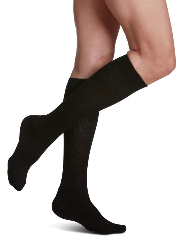 Legs of female model in knee-length Sigvaris Cushioned Cotton compression calf socks in black.