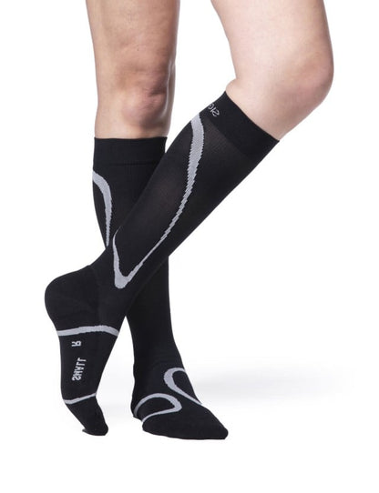 Legs of female model wearing Sigvaris High Tech compression calf socks in black.