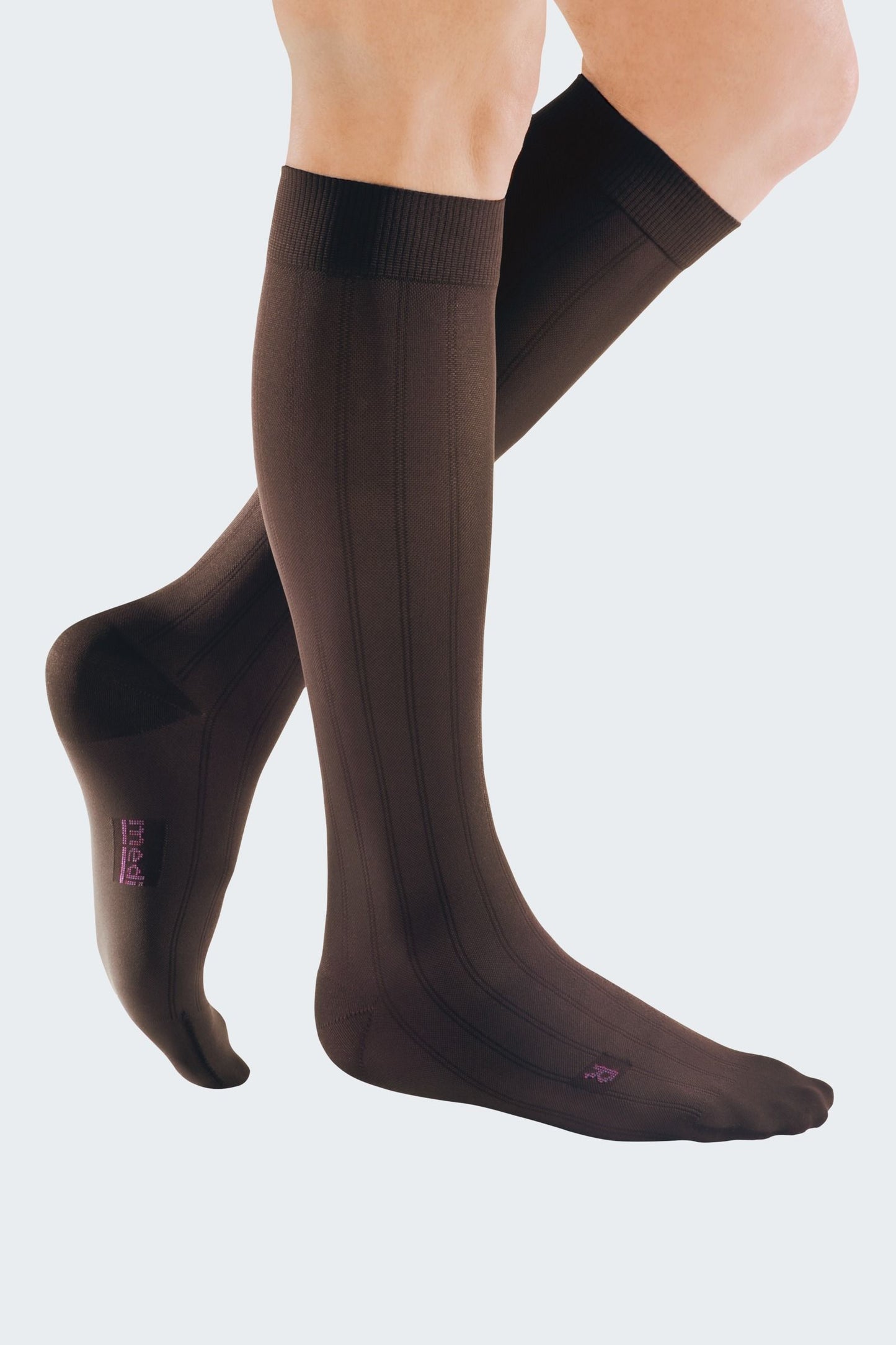 Lower legs of model in knee-high Mediven Men's dress compression socks in brown.