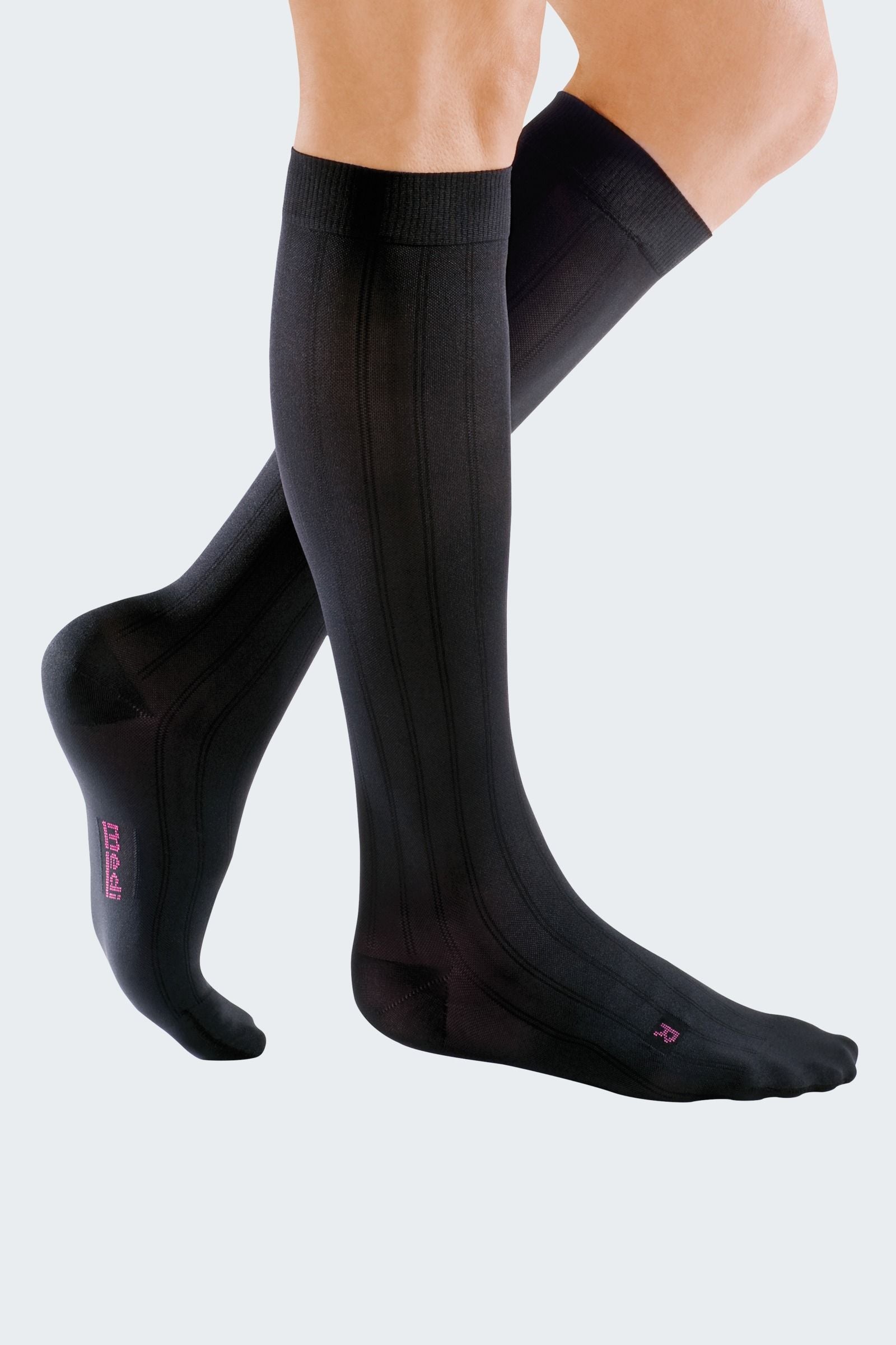 Lower legs of model in knee-high Mediven Men's dress compression socks in black.