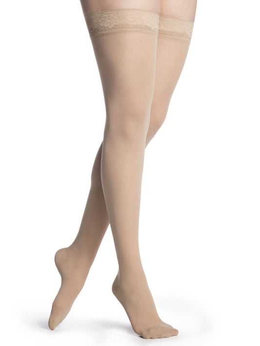 Legs of female model in thigh-high Sigvaris Soft Opaque compression tights in honey.