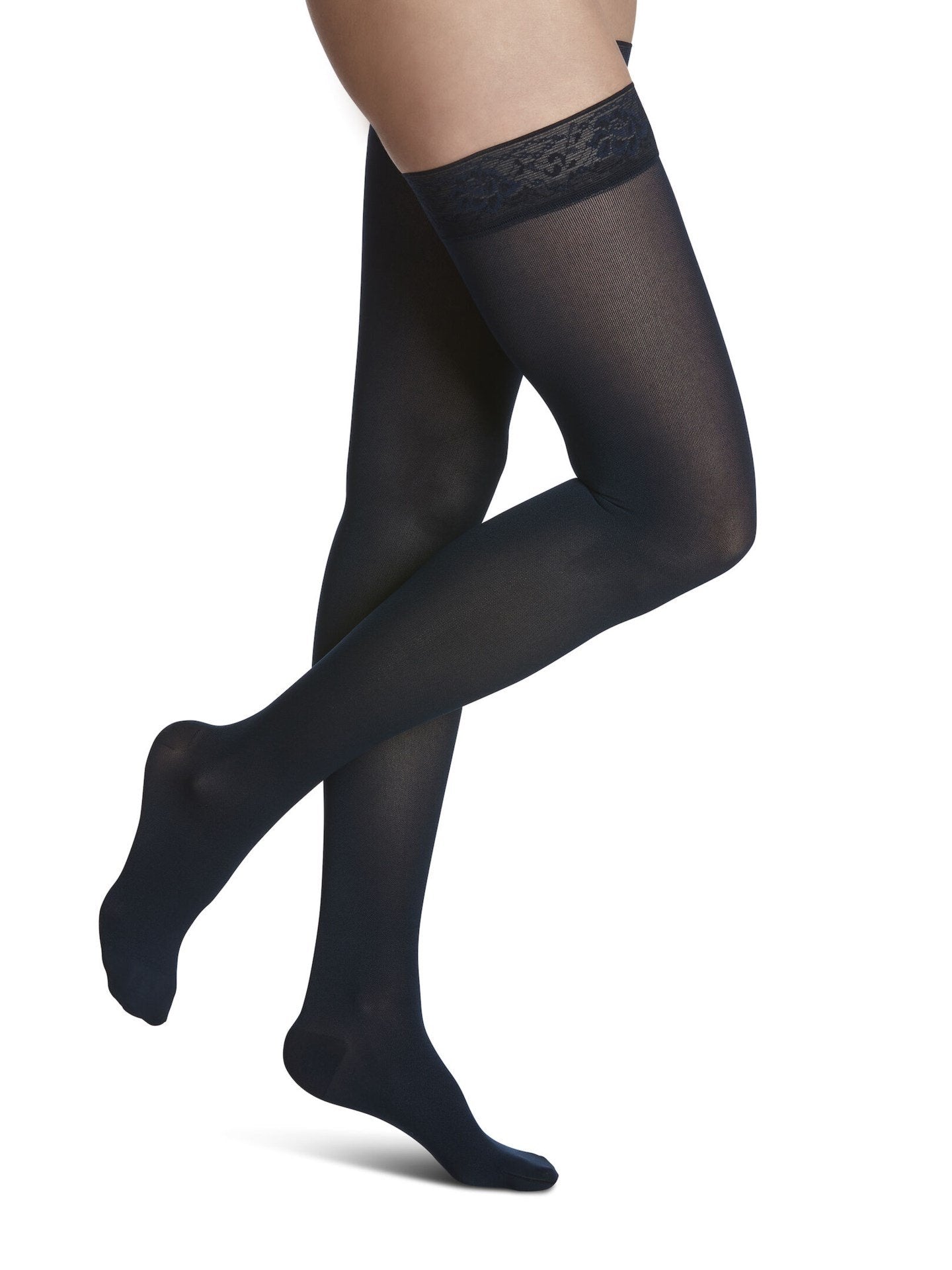 Legs of female model in thigh-high Sigvaris Soft Opaque compression tights in midnight blue.