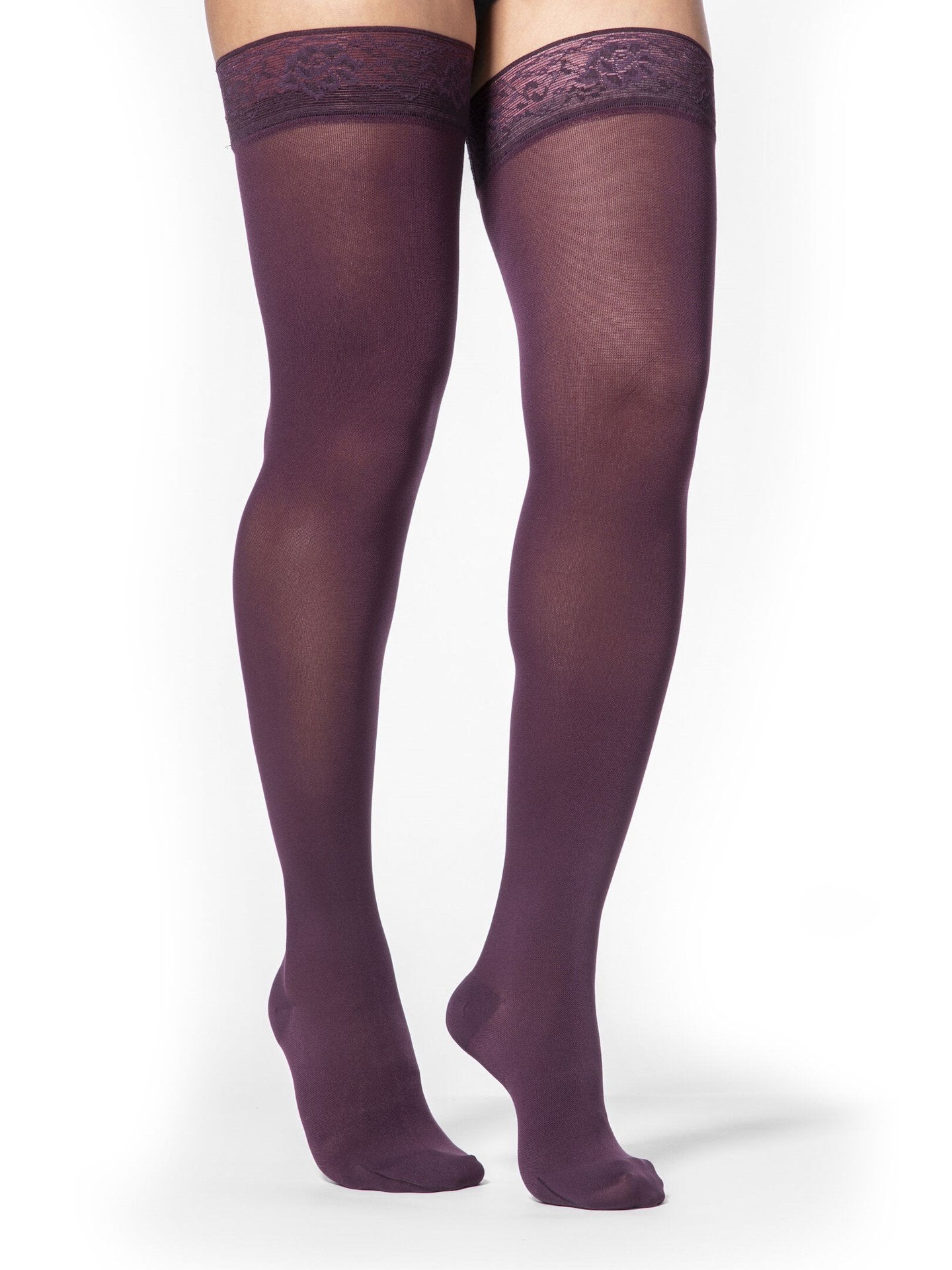 Legs of female model in thigh-high Sigvaris Soft Opaque compression tights in mulberry.