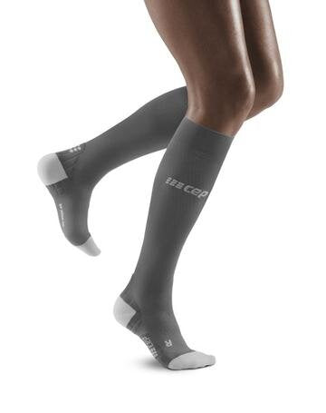 Lower legs of model in knee-high CEP Ultralight Running compression socks in grey, with white toes and heels.