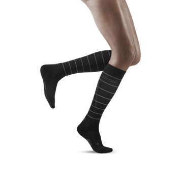 Lower legs of model in knee-high CEP Reflective running compression socks in black.