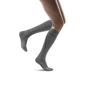 Lower legs of model in knee-high CEP Reflective running compression socks in grey.