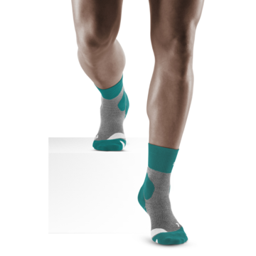 Lower legs of model in CEP Merino Wool compression socks in green.