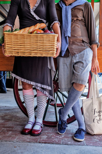 Lunatik Bofa Tech compression socks on two women in comfortable clothing at a farmer's market, one holding a basket of produce.