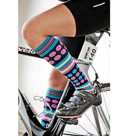 Model wearing Lunatik Rockin Dot+ compression socks in black on a bicycle.