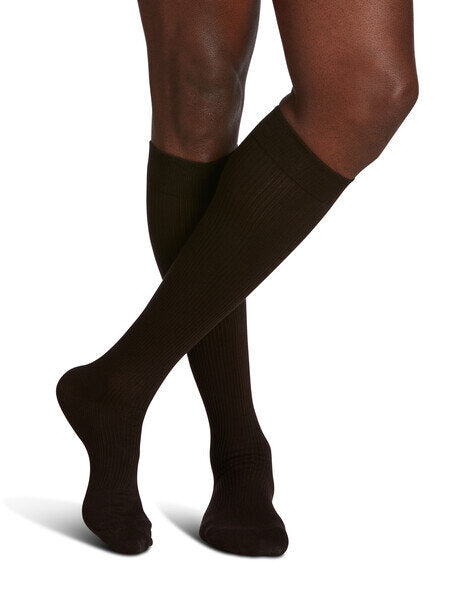 Legs of model in Sigvaris Casual Cotton compression socks (black mist) on white background.