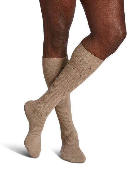 Legs of model in light beige Sigvaris Casual Cotton compression socks on white background.