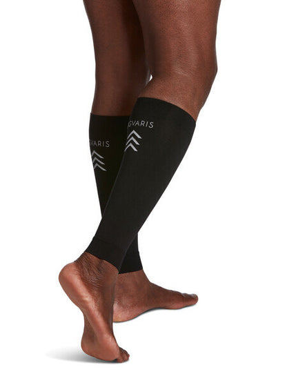 Legs of model in black Sigvaris Calf Performance compression sleeves on white background.