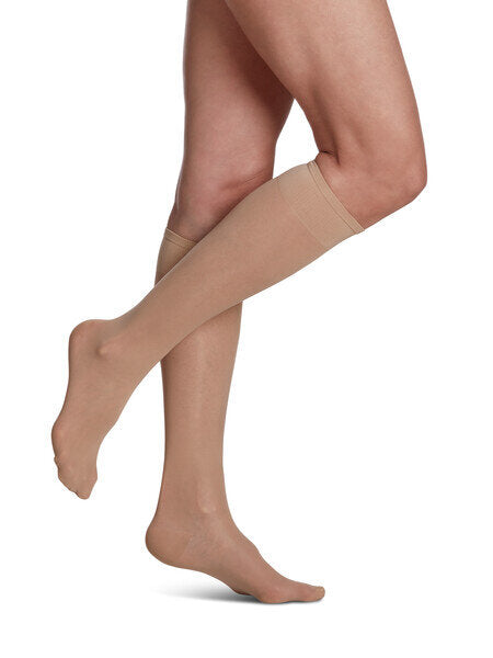 Legs of model in Sigvaris Sheer compression calf socks in warm sand.