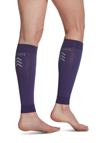 Legs of model in purple Sigvaris Calf Performance compression sleeves on white background.