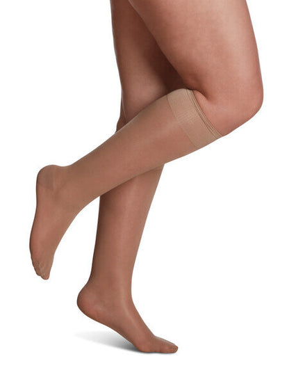 Legs of model in Sigvaris Sheer compression calf socks in golden.