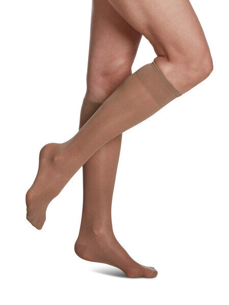 Legs of model in Sigvaris Sheer compression calf socks in honey.