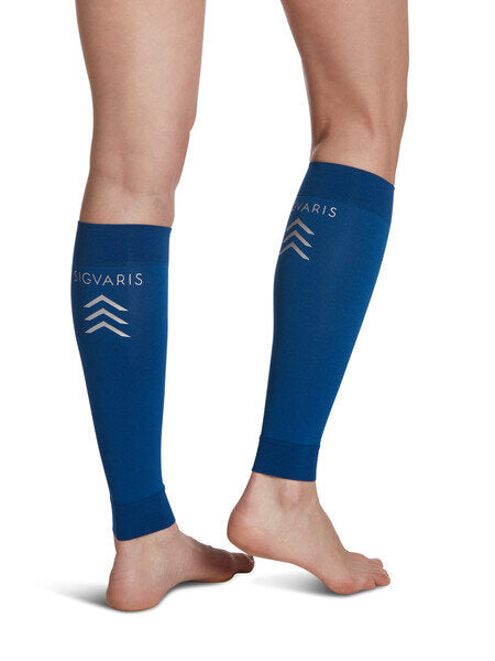 Legs of model in dark blue Sigvaris Calf Performance compression sleeves on white background.