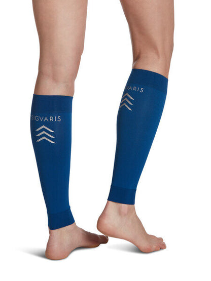 Legs of model in dark blue Sigvaris Calf Performance compression sleeves on white background.