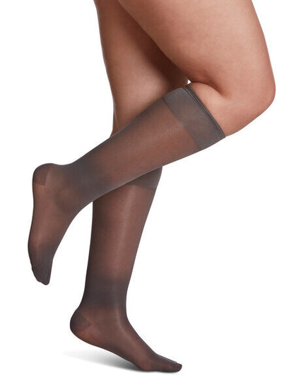 Legs of model in Sigvaris Sheer compression calf socks in charcoal/night shade.